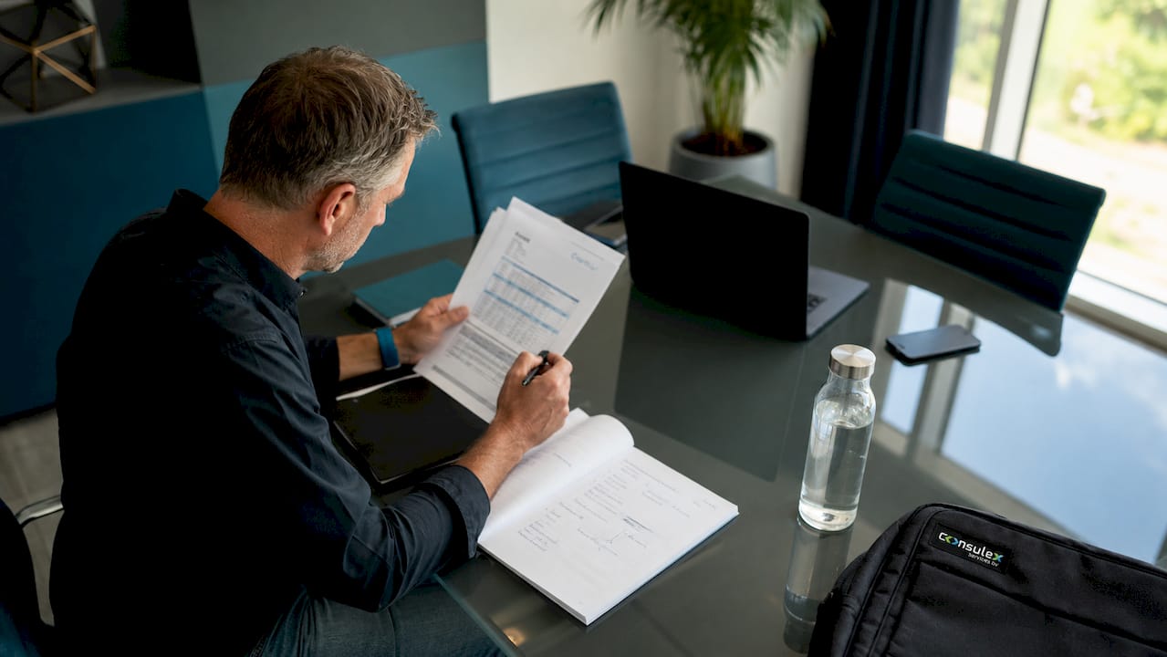Een man controleert het ISO-certificaat en de bijbehorende documenten.