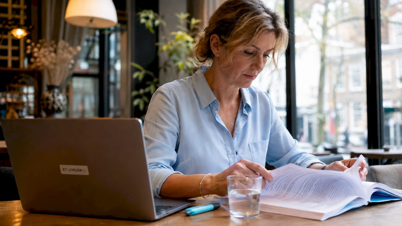 Zakenvrouw buigt zich op kantoor over het NEN 9001-document