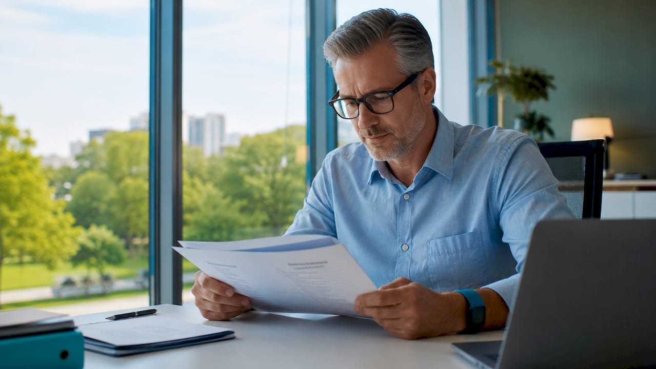 Een medewerker verdiept zich op kantoor in de compliance-richtlijnen.