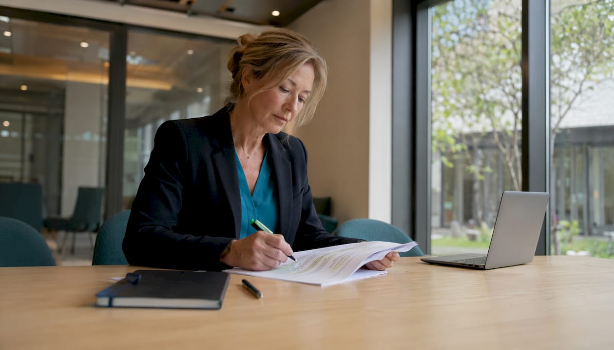 Op kantoor loopt de compliance officer de documenten zorgvuldig na.